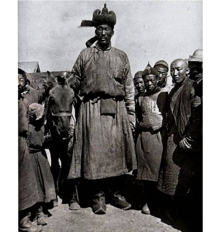 Giant photographed in Ulaan Baatar, Mongolia in 1922. Assuming even an average height of 5’4″ for his companions, this giant must have towered close to 8 feet tall — truly a giant among unusually small Mongolians. The man is considered one of the original giant descendants of Magog. Photo credits: Steve Quayle